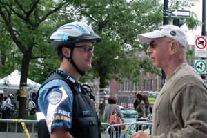 Un policier &agrave; v&eacute;lo de la brigade urbaine et un citoyen